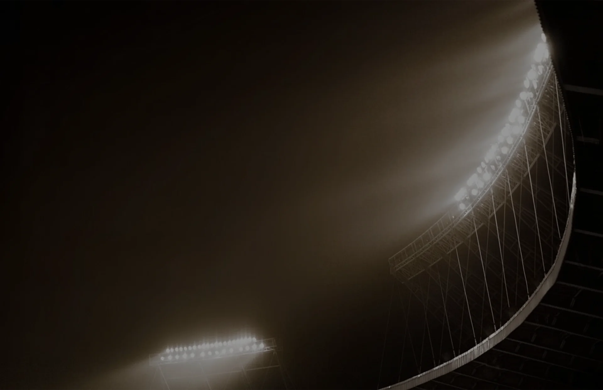 Stadium floodlights shining through fog at night. (photo)